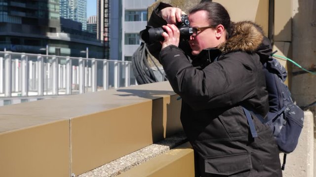 Photographer on top of roof taking photos of downtown and reviewing 1
