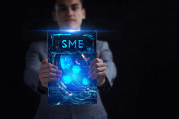 Business, Technology, Internet and network concept. Young businessman working on a virtual screen of the future and sees the inscription: SME