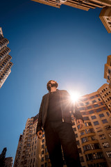 Low angle shot of young guy, standing in the urban block.