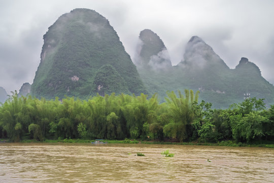 Small boat on the Li River valley while passing Xingpingzhen fishing village in the vicinity of Yangshuo near Guilin