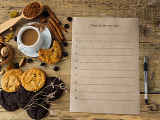Plans for the new year. The inscription on the Kraft sheet. Coffee, nuts and other sweets on a...