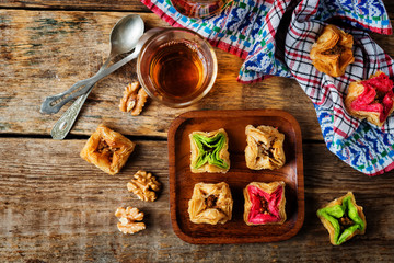 Multicolored baklava, Oriental sweetness on a plate with tea