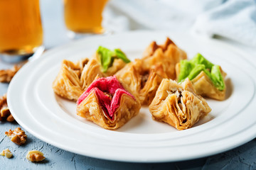 Multicolored baklava, Oriental sweetness on a plate with tea