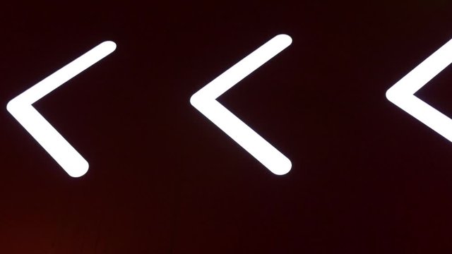 flashing arrow, sign, pointer on a dark background. Luminous road signs