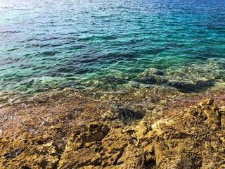 Fototapeta na wymiar Beautiful texture with the sea and the shore. Rocky seashore and blue sea water.