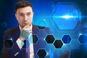 Business, Technology, Internet and network concept. Young businessman working on a virtual screen of the future and sees the inscription: Government