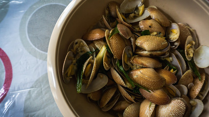 Close up view of the Lala or saltwater clams cooked with oyster sauce, ginger, garlic and onions in a bowl.