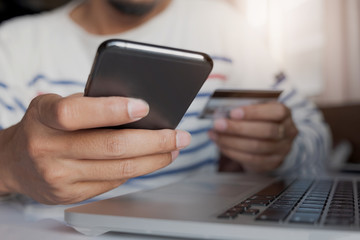 Online payment,Man's hands holding smartphone and using credit card for online shopping. Cyber Monday Concept