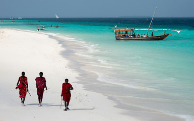 Masai, toeristen vermakend op het strand in Nungwi. Zanzibar, Tanzania, Oost-Afrika.