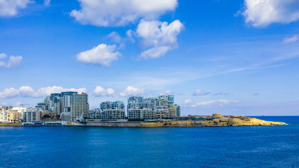 Obraz premium Tigne Point at the end tip of Sliema with its modern apartments next to Fort Tigne which is one of the oldest polygonal forts in the world built by the Order of Saint John in the 18th century.