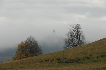 Observation / lookout tower in the clouds on foggy autumn morning. Czech countryside. 