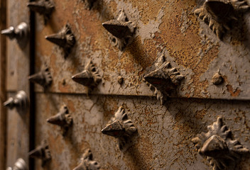 closeup of a medieaval door with metal spines in genua, italy
