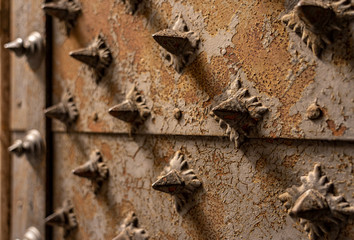 closeup of a medieaval door with metal spines in genua, italy