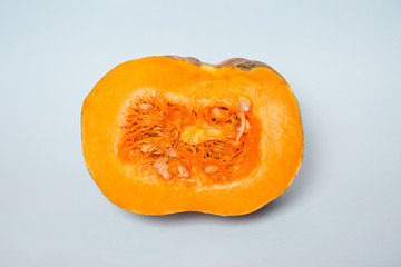 Media calabaza cortada en fondo azul celeste.