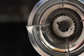 top view of part of shiny silver gas stove. black background