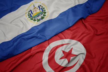 waving colorful flag of tunisia and national flag of el salvador.