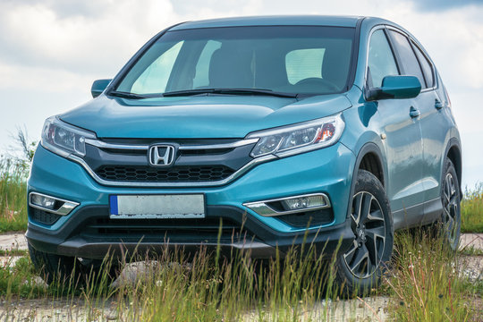 popular family SUV in mountains on a cloudy day. 4th generation of a honda cr-v, in blue color. all wheel drive vehicle on a paved platform. car adventure concept