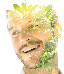 Double exposure of a young handsome man’s portrait blended with bright green leaves, showing the perfect beauty of nature's creation