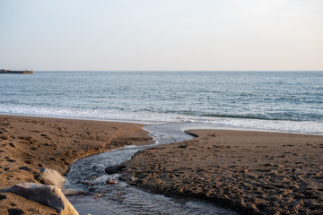 夕焼け 砂浜の川 水の流れ