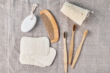 Fototapeta na wymiar Natural set for bathing bamboo toothbrushes, luffa spongle and wooden hairbrush on a linen background. Zero waste no plastic concept