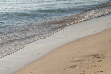 Nature background of seashore beach wave and coastline sand with sunlight water surface for holiday relaxation lifestyle concept