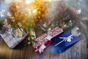 Colorful Christmas presents under the tree with Christmas lights