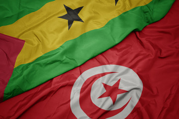waving colorful flag of tunisia and national flag of sao tome and principe .