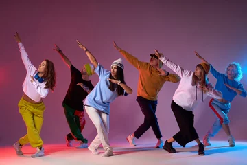 Fotobehang Modern dancers posing in front of studio background, performing modern dance element, professional group of dancers preparing for concert, practicing movies © alfa27