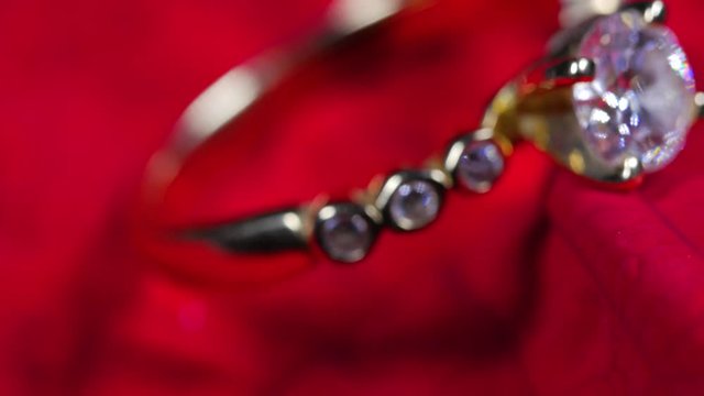 Beautiful Macro close up of gold ring with diamond on red leaf rotating around