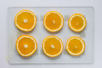 Cutted orange on glass cutboard on white background