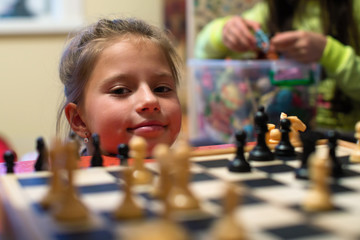 Cute little girl portrait and chess.