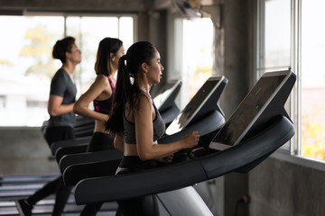 Fototapeta na wymiar Group of friends run treadmills in gym