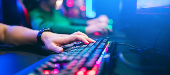 Professional cyber video gamer studio room with personal computer armchair, keyboard for stream in neon color blur background. Soft focus - obrazy, fototapety, plakaty
