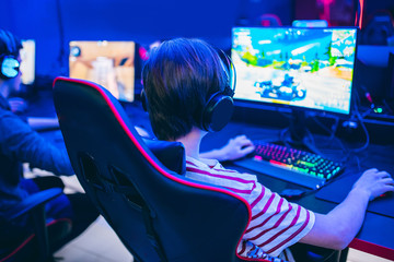 Professional gamer playing tournaments online video games computer with headphones, red and blue