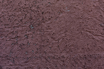 the porous texture of the red wall