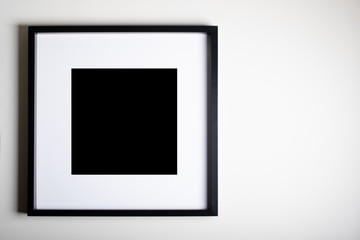 empty black  square frame on the wall