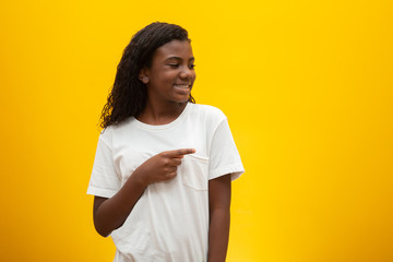 African American girl with curly hair on yellow background. Smiling black kid with a black power hair. Black girl with a black power hair. African descent.