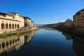 Fototapeta na wymiar scenic view to Arno river from ponte vecchio in florence italy with bright blue sky