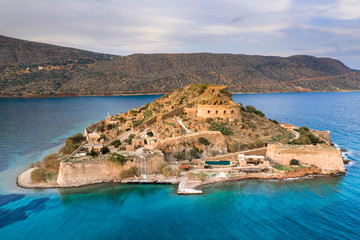 Fototapeta na wymiar View of the island of Spinalonga with calm sea. Here were isolated lepers, humans with the Hansen's desease, gulf of Elounda, Crete, Greece. 
