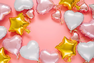 Frame made of air balloons of heart shaped and stars.  Holiday and celebration. Birthday party decoration. Colorful Metallic air balloons on pink background.