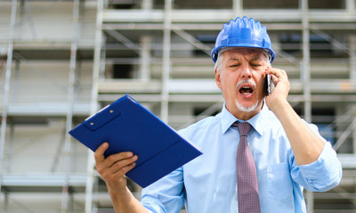 Angry senior engineer shouting at the phone
