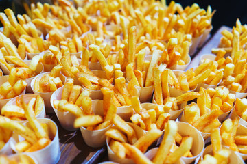 French fries in paper cups. Catering and guest meals during the event.