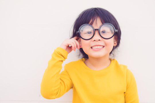 Happy smiling smart and nerd little asian girl in glasses and pointing finger at brain and going to school for the first time.Child with school kindergarten.Child development and Education concept.