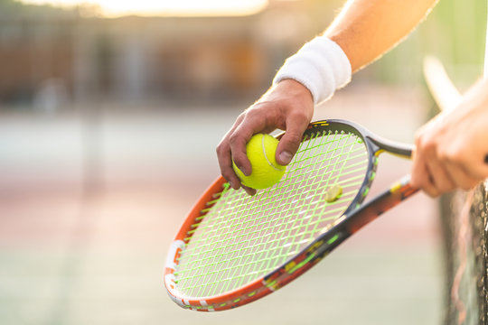 Close Up of Tennis Player Hands Holding Racket with Ball.
