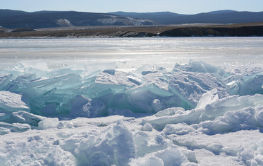Blue ice of Lake Baikal covered with cracks and hummocks, Russia. The Eastern Siberia.