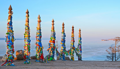 Wooden ritual pillars with colorful ribbons on Olkhon Island, Lake Baikal, Khuzhir, Siberia, Russia