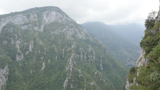 Slow pan on Olympus mountain scenery with fog over the peaks 4K video