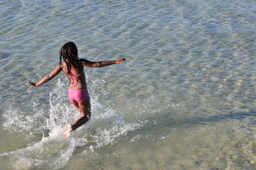 Fototapeta premium Girl splashing through shallow water