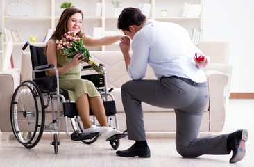 Fototapeta na wymiar The man making marriage proposal to disabled woman on wheelchair