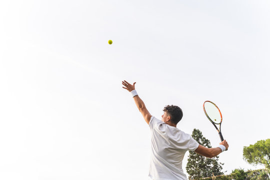 Young Man Playing Tennis Outdoors.